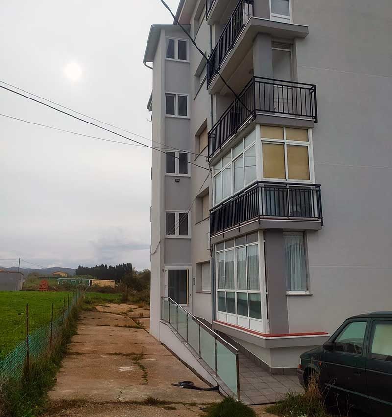 Edificio de pisos gris con instalación de ascensor