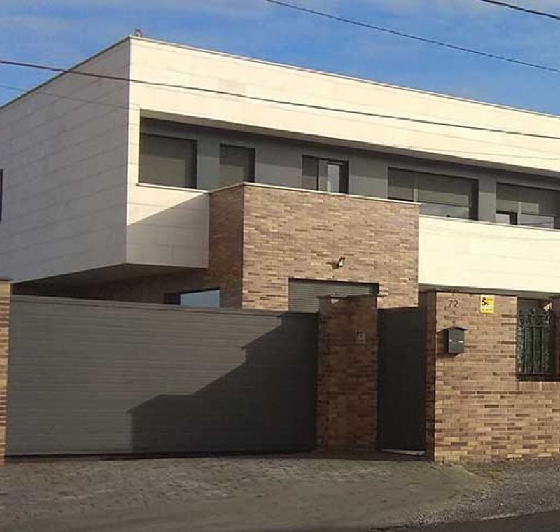 Cerramiento exterior de ladrillo con chalet de dos plantas