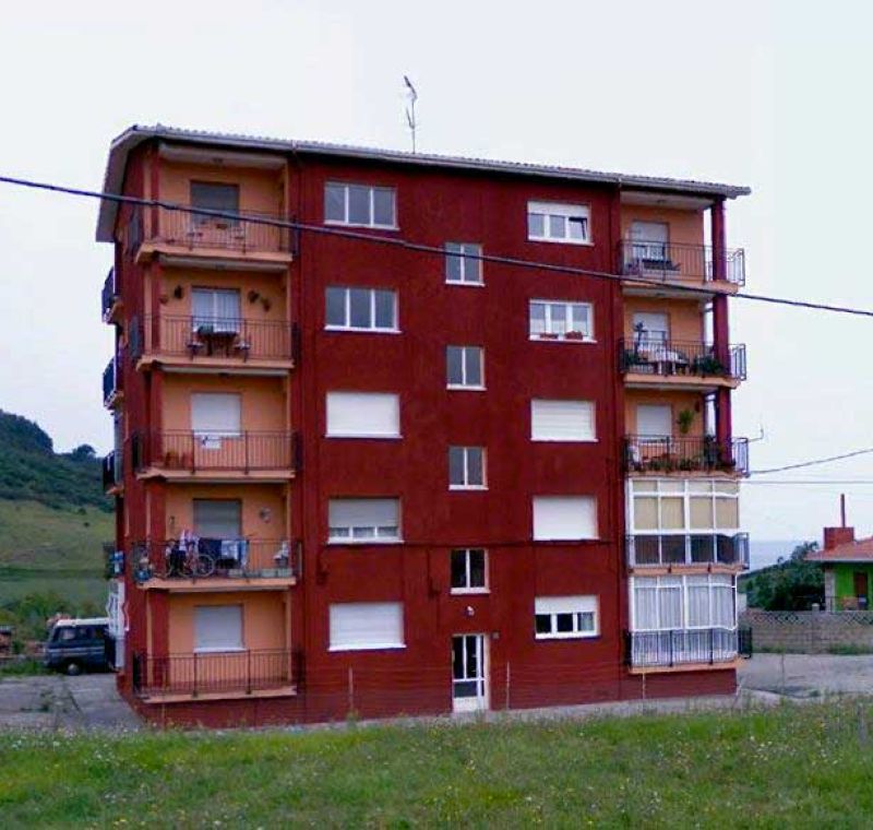 Edificio rojo de pisos antes de la instalación del ascensor