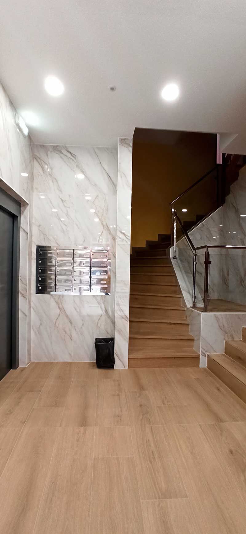 Interior de portal con ascensor y escaleras