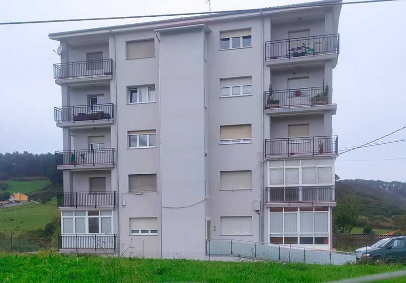 Edificio de pisos gris con instalación de ascensor
