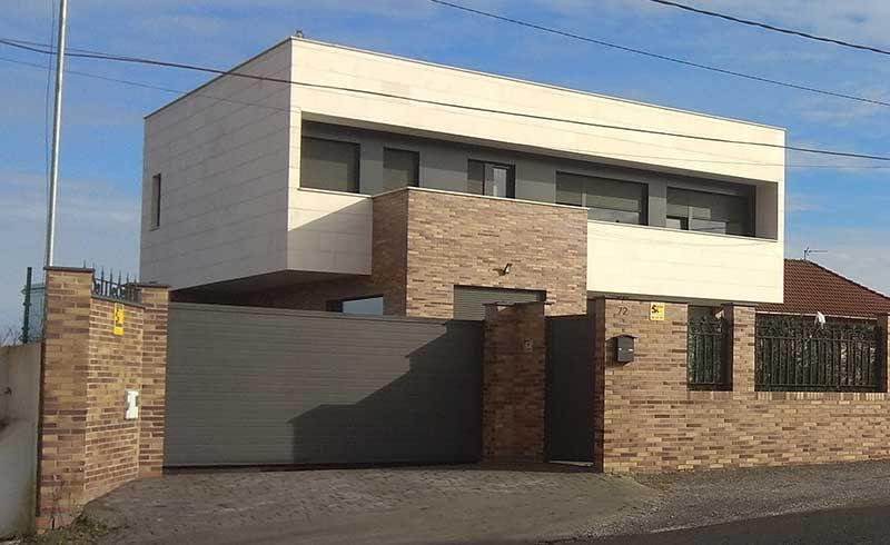 Cerramiento exterior de ladrillo con chalet de dos plantas